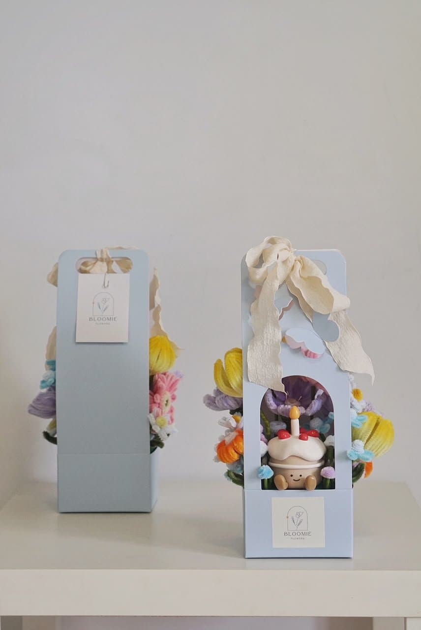 Pastel blue Bloomie gift boxes filled with handmade flowers and a small character figure
